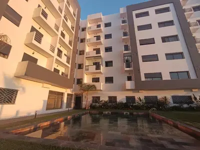 an apartment building with a swimming pool in front of it at Nouaceur Suite avec Piscine Casa Aéroport AirNest in Nouaseur