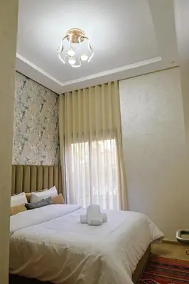 a bedroom with a large white bed with a chandelier at Cozy Modern Studio Near Zenâta Beach in Casablanca