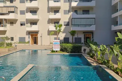 a swimming pool in front of a building at Cozy Modern Studio Near Zenâta Beach in Casablanca