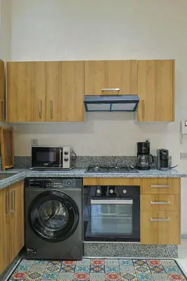 a kitchen with a stove and a washing machine at Cozy Modern Studio Near Zenâta Beach in Casablanca