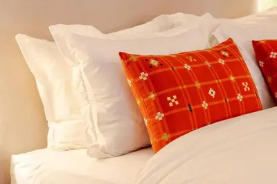 a bed with white pillows and a red pillow at Loft - Literie Premium, Fibre optique, IPTV, GYM, Terrasse in Casablanca