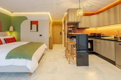 a bedroom with a large bed and a kitchen at Loft - Literie Premium, Fibre optique, IPTV, GYM, Terrasse in Casablanca
