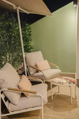 a group of chairs and a table with an umbrella at Loft - Literie Premium, Fibre optique, IPTV, GYM, Terrasse in Casablanca