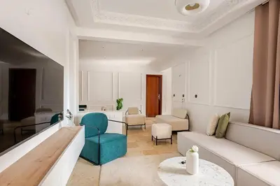 a living room with blue chairs and a couch at Agdal Train Station Modern&Stylish Apartments in Rabat