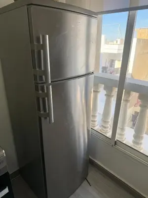 a stainless steel refrigerator in a room with a window at Lumineux cosy appartement - océan Rabat in Rabat