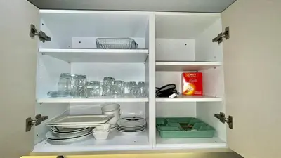 a white cabinet with plates and dishes in it at Luxurious studio with unobstructed view in Casablanca