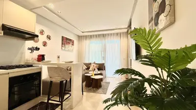a kitchen with a living room with a potted plant at Luxurious studio with unobstructed view in Casablanca
