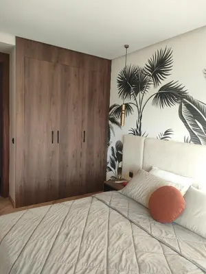 a bedroom with a bed with a large wooden door at Studio neuf - haut standing in Casablanca
