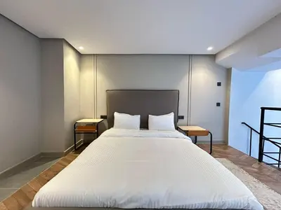 a bedroom with a large white bed with two tables at Carrington Stay 13 in Casablanca