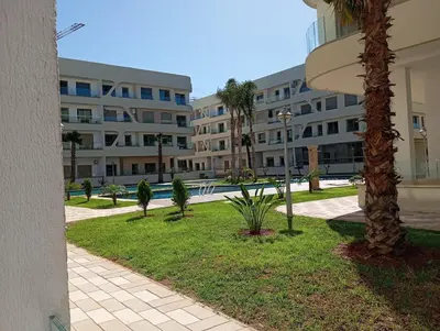 a park with palm trees and a building at Garden paradis bouznika in Bouznika