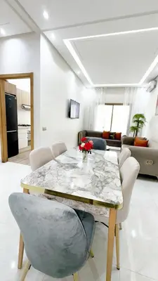 a living room with a marble table and chairs at Garden paradis bouznika in Bouznika