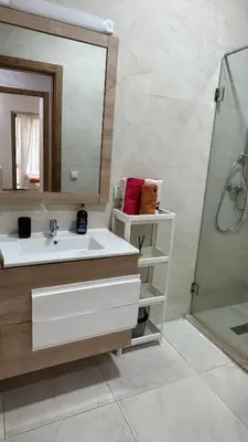 a bathroom with a sink and a mirror and a shower at Garden paradis bouznika in Bouznika