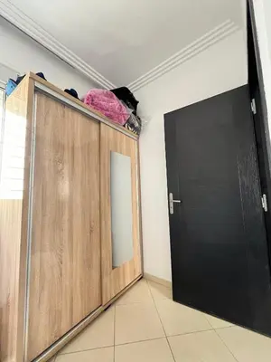 a room with a wooden cabinet and a door at Zenata Family Apartment in Aïn Harrouda