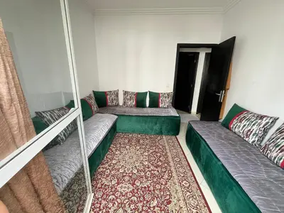 a living room with two couches and a rug at Zenata Family Apartment in Aïn Harrouda