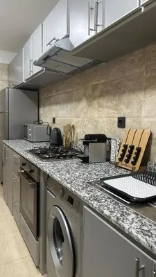 a kitchen with a stove and a washing machine at Confort et mer Océan Rabat in Rabat