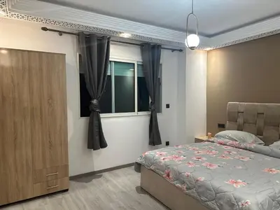 a bedroom with a bed and a window with curtains at Confort et mer Océan Rabat in Rabat