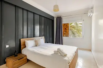 a bedroom with a bed with a black accent wall at Authentic & Spacious 2 Bedrooms Heart of Rabat in Rabat