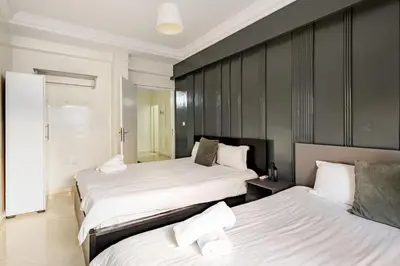 two beds in a hotel room with white sheets at Authentic & Spacious 2 Bedrooms Heart of Rabat in Rabat