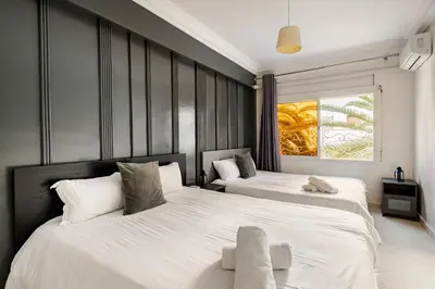 a bedroom with two beds with white sheets at Authentic & Spacious 2 Bedrooms Heart of Rabat in Rabat
