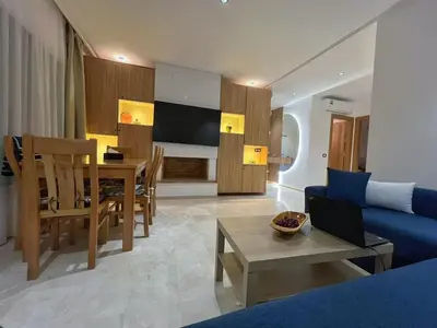 a living room with a blue couch and a table at Charmante maison de vacances proche de la plage à quelques minutes de Rabat in Temara