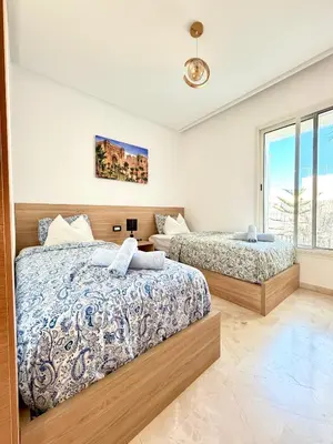 a bedroom with two beds and a window at Charmante maison de vacances proche de la plage à quelques minutes de Rabat in Temara