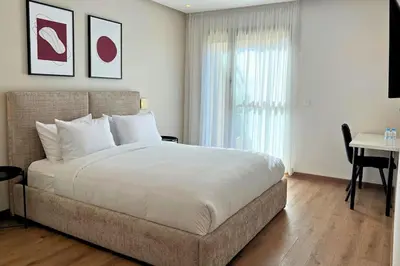 a bedroom with a bed and a desk and a window at Luxury Apartment with a Stunning Sea View - Rabat in Rabat