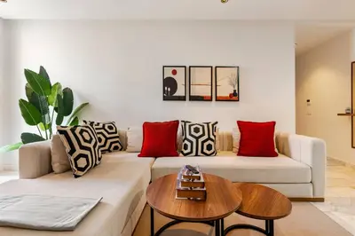 a living room with a white couch and red pillows at Appartement Design avec Parking et Salle de Sport Ferme Bretonne in Casablanca