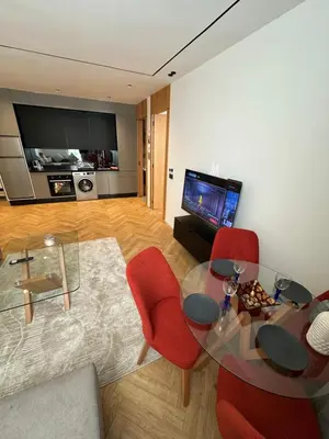 a living room with a glass table and red chairs at Casablanca Maarif in Casablanca