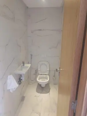 a white bathroom with a toilet and a sink at 2 min walk from Four Seasons Hotel-Cozy Terrace Stay in the Heart of Rabat in Rabat