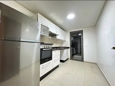 a kitchen with white cabinets and a stainless steel refrigerator at RDJ 2CH haut standing - Bouskoura in Bouskoura