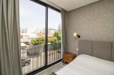 a bedroom with a bed and a large window at B5 Modern bright studio with city view in Casablanca