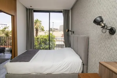 a bedroom with a bed and a large window at B5 Modern bright studio with city view in Casablanca