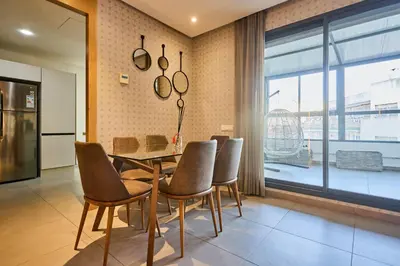 a dining room with a table and chairs and a window at Terrasses and Sunset Duplex Luxe 3 Bed in Ghandi in Casablanca