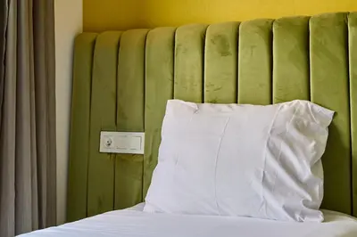 a bed with a white pillow next to a green headboard at Terrasses and Sunset Duplex Luxe 3 Bed in Ghandi in Casablanca