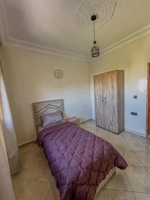 a bedroom with a purple bed and a wooden door at 3-Bedroom Apartment - Rabat - 2Baths & 2Balconies in Rabat