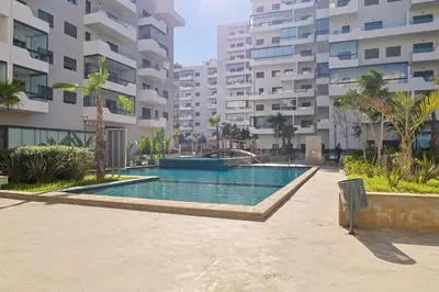 a swimming pool in the middle of a building at Studio Cosy avec Piscine & proche de la plage in Aïn Harrouda