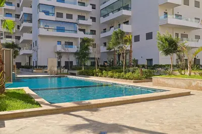 a swimming pool in front of a building at Studio Cosy avec Piscine & proche de la plage in Aïn Harrouda