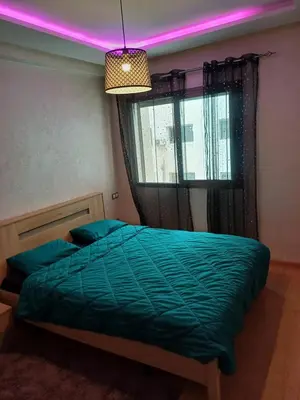 a bedroom with a green bed with a pink light at Mohemmadia in Mohammedia