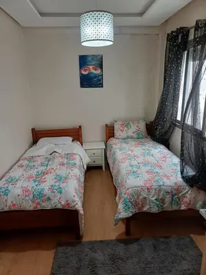 a bedroom with two beds and a picture on the wall at Mohemmadia in Mohammedia
