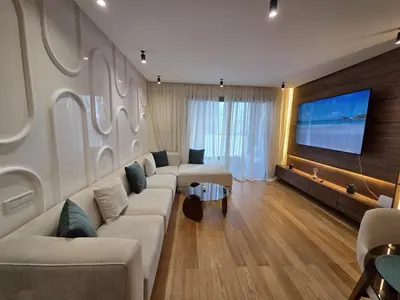 a living room with a couch and a flat screen tv at Luxury 1 bedroom at La marina in Casablanca