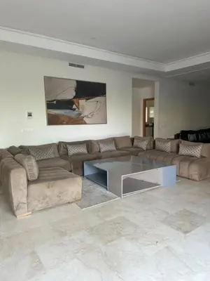 a living room with a couch and a glass table at A beautiful luxury villa in Rabat in Aïn el Apuda