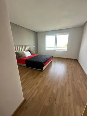 a bedroom with a bed and a wooden floor at A beautiful luxury villa in Rabat in Aïn el Apuda