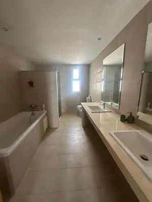 a bathroom with two sinks and a tub and a mirror at A beautiful luxury villa in Rabat in Aïn el Apuda