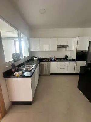 a kitchen with white cabinets and a black counter top at A beautiful luxury villa in Rabat in Aïn el Apuda