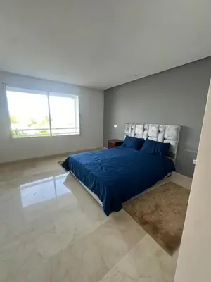 a bedroom with a blue bed and a large window at A beautiful luxury villa in Rabat in Aïn el Apuda