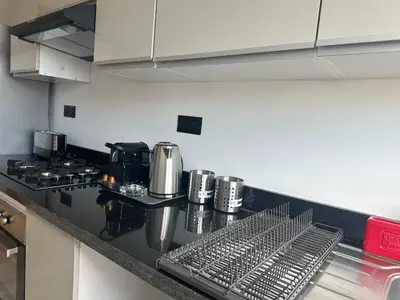 a kitchen with a counter top with a stove and a counter sidx sidx at Appartement 1BR Prestige & Confort à Hay Riad in Rabat