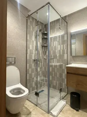 a bathroom with a shower with a toilet and a sink at Appartement 1BR Prestige & Confort à Hay Riad in Rabat