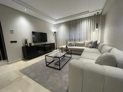 a living room with a white couch and a tv at Studio a 2 pas des TWINS CENTER boulevard Massira Khadra in Casablanca