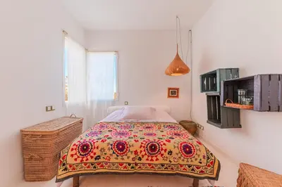 a bedroom with a bed with a colorful blanket on it at Cabanon Rêve Bleu terrace and infinite horizon in O Ben Slimane