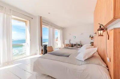 a bedroom with a large bed with a view of the ocean at Cabanon Rêve Bleu terrace and infinite horizon in O Ben Slimane